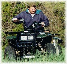 Dave riding the 4-wheeler in the field.