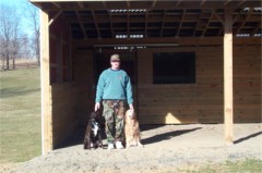 A closer view of Dave proudly posing in front of his completed shed with Farley and Juli.